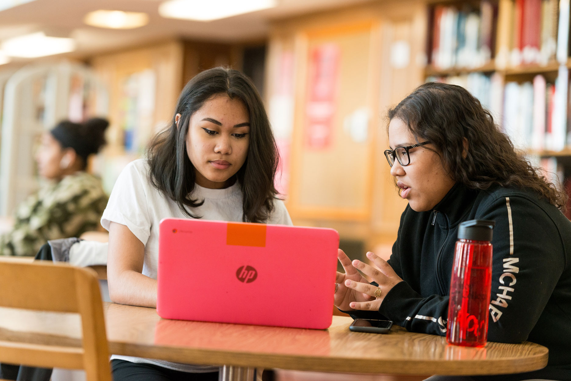 Students at Molloy University working on a pink HP laptop